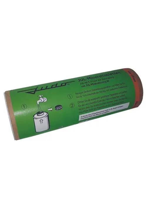 Brauner Kartonbehälter mit grüner Beschriftung von Judo, der Anweisungen zur Verwendung von Mineraltabletten zeigt. Darstellung von Wasserhahn und Behälter mit Dosierhinweisen.